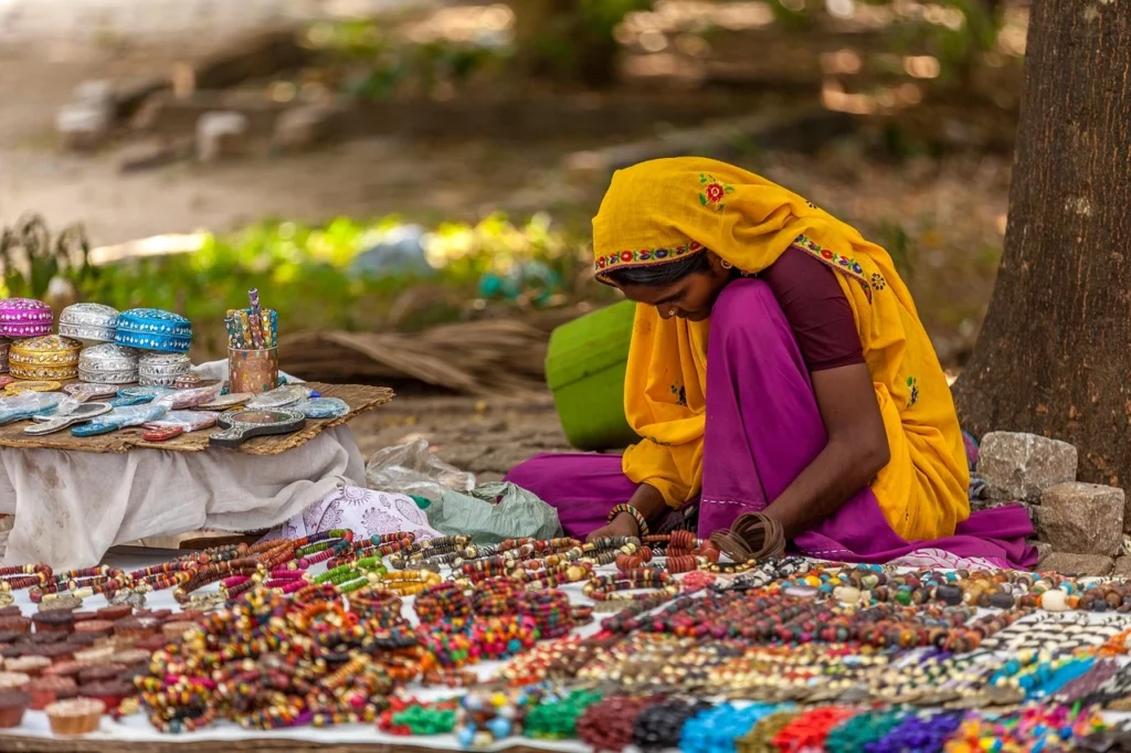 Indian women in a street markets setting, selling handmade necklaces and jewellery