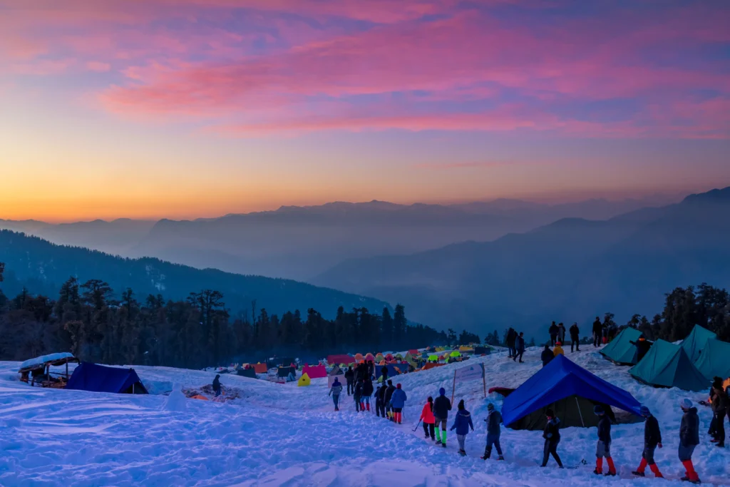 Hikers walking on the snow-covered Kedarkantha Trek trail in Uttarakhand, India